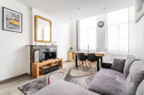 un salon avec un canapé, une télévision et une table dans l'établissement Le séjour Douaisien - Proche Gare & Centre, à Douai