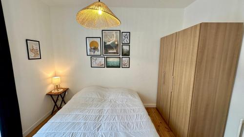 une chambre avec un lit et une armoire en bois dans l'établissement Le Beau Site 4 Le Mont Dore 6 pers, à Le Mont-Dore