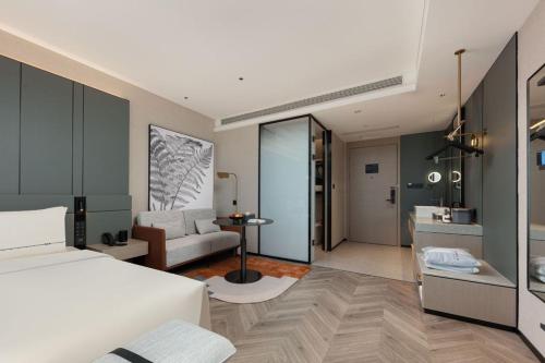 a bedroom with a bed and a living room at Atour S Hotel Xiamen Gaoqi Airport Huli District Government in Xiamen