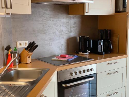 a kitchen with a sink and a stove top oven at Wellness-Residenz Wohnung 12 in Zingst