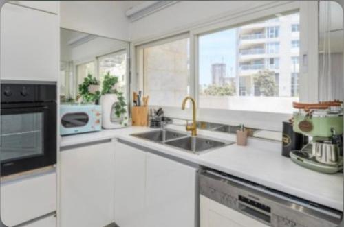 a white kitchen with a sink and a microwave at sea view Vila-5BDR in Netanya
