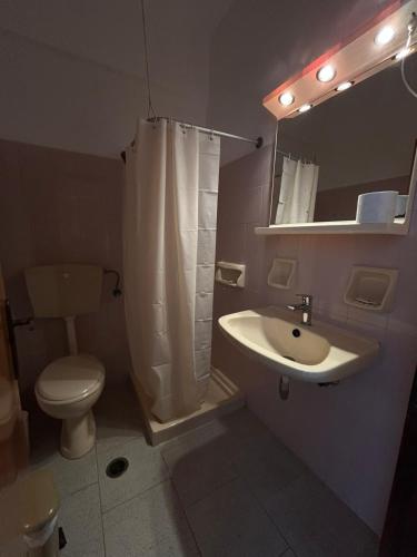 a bathroom with a sink and a toilet and a mirror at Smalis Studios in Lakkíon