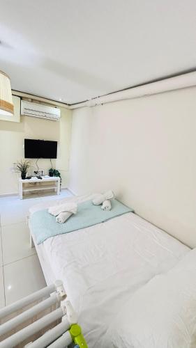 a white room with two beds and a flat screen tv at sea view Vila-5BDR in Netanya