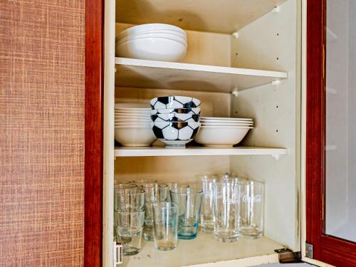 a cupboard filled with glasses and bowls and plates at The M HIGASHIMACHI in Nakatsugawa