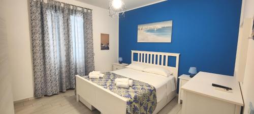 Un dormitorio azul con una cama y una pared azul. en Appartamento Dolceluna, en San Vito lo Capo