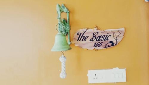 a sign on a wall with a bell and a lightswitch at The Basic in Bhubaneshwar