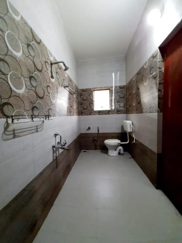 a bathroom with a toilet and a window at The Basic in Bhubaneshwar