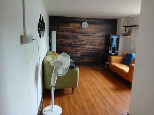 a room with a green couch with a fan at The Basic in Bhubaneshwar