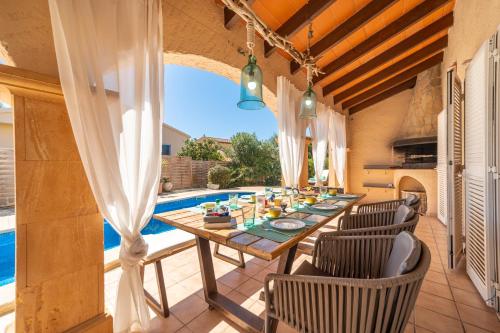 eine Terrasse mit Tisch und Stühlen neben einem Pool in der Unterkunft Villa Son Serra, Pool and Chill Out close to the beach in Son Serra de Marina