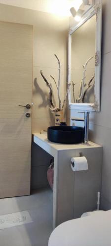 a bathroom with a sink and a mirror and a toilet at House On The Wave in Marathokampos