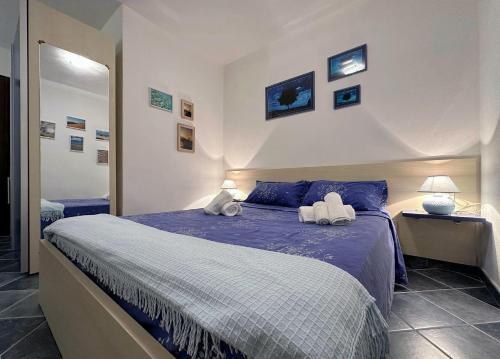 a bedroom with a bed with two towels on it at Spiaggia a 5 Minuti, Giardino e Vista Mare - Due Splendide Villette Indipendenti in Palau