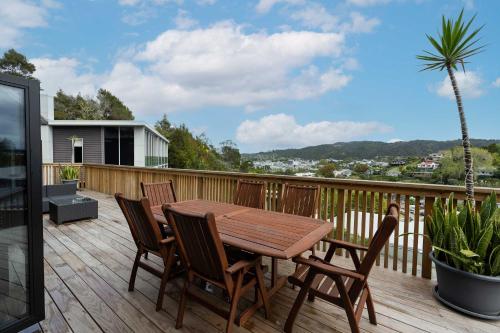 a wooden deck with a wooden table and chairs at Riverside Heights Two Story Townhouse with a View in Whangarei