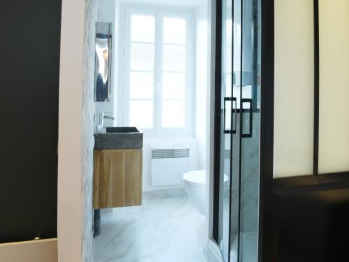 une salle de bain avec un lavabo et des toilettes dans l'établissement Le Cocon studio, cognac, à Cognac