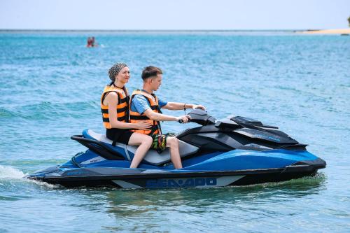 two people riding on a jet ski in the water at The Calm Resort & Spa in Pasikuda