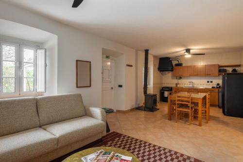 a living room and kitchen with a couch and a table at Casa Moinho by Olala Homes in Santiago do Cacém
