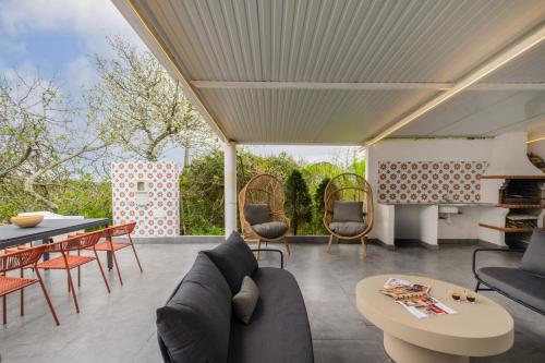 a living room with a couch and a table and chairs at Casa Moinho by Olala Homes in Santiago do Cacém