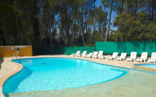 une piscine avec des chaises longues et une clôture dans l'établissement Studio avec jardinet dans résidence avec piscine, à Sanary-sur-Mer