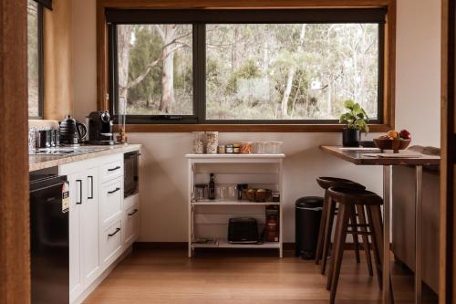 a kitchen with white cabinets and a large window at Eagle Ridge Retreat in Kettering