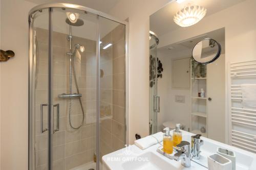 une salle de bain avec une douche, un lavabo et un miroir dans l'établissement Magical Rooftop Views Historic City Center 2 guests, à Honfleur