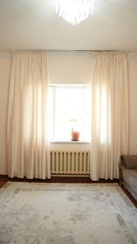 a living room with a window with a couch and a radiator at Hostelhome in Türkistan