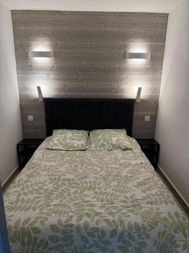 un lit avec deux oreillers dessus dans une chambre dans l'établissement Appartement cosy, à Allevard