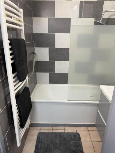 une salle de bain avec une baignoire et un lavabo dans l'établissement Appartement cosy, à Allevard