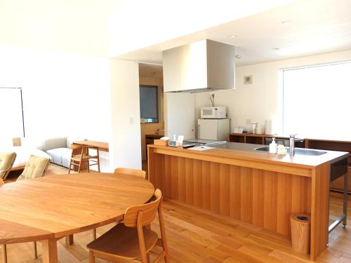 a kitchen and living room with a table and a kitchen and a dining room at takane no mori no cottage in Gotemba