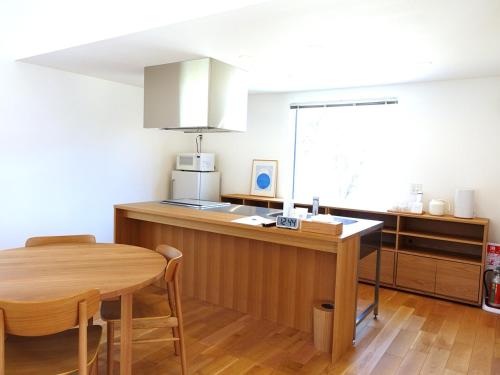 a kitchen with a wooden table and a dining room at takane no mori no cottage in Gotemba