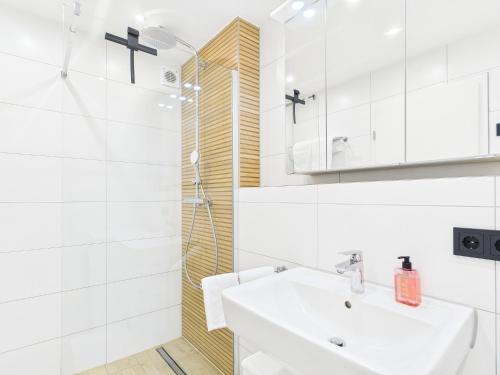 Un baño blanco con lavabo y ducha en Hochwertige Ferienwohnung in Seenähe mit Terrasse & Vollausstattung, en Uhldingen-Mühlhofen