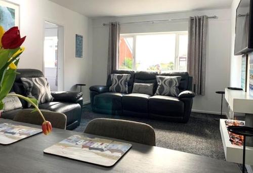 ein Wohnzimmer mit Sofa und Tisch in der Unterkunft Primrose Valley Bungalow in Filey