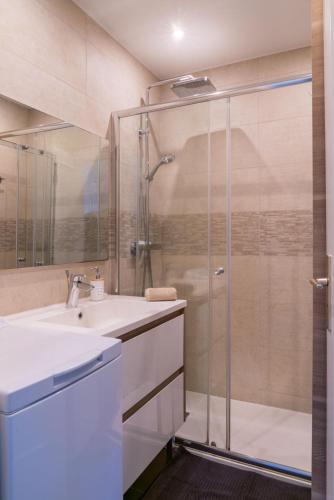 une salle de bain avec une douche en verre et un lavabo dans l'établissement Eden Bleu, parking, piscine, tennis et soleil, à Antibes