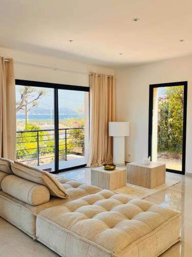 - un salon avec un grand canapé et de grandes fenêtres dans l'établissement La Villa 239, à Fréjus