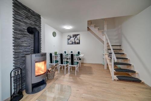 a living room with a fireplace and a staircase at Chaloupka u jezera pod smrkem in Červené Janovice