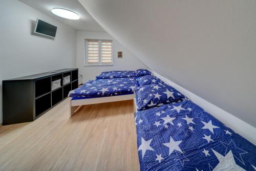 a bedroom with a bed with a blue comforter at Chaloupka u jezera pod smrkem in Červené Janovice