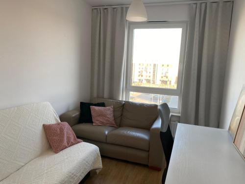 a living room with a couch and a window at Przytulne mieszkanie na krótki pobyt, spacerem na starówkę in Toruń