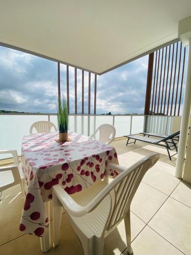 une table avec un tissu de table fleuri sur un balcon dans l'établissement Appartement avec terrasse et parking - v0841, à Vias