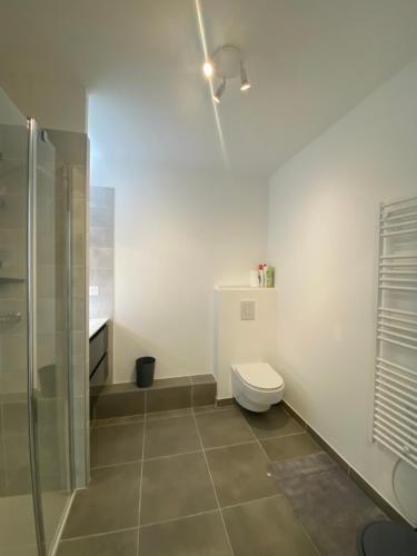 une salle de bain blanche avec toilettes et douche dans l'établissement Appartement avec terrasse et parking - v0841, à Vias