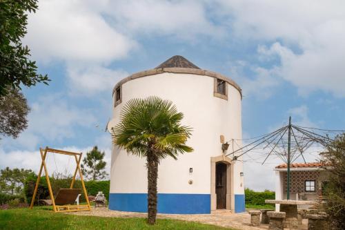 a lighthouse with a palm tree and a swing at Casa Moinho by Olala Homes in Santiago do Cacém