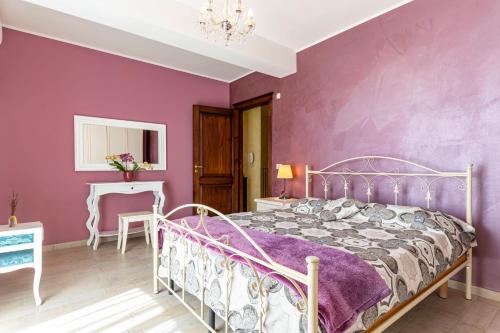 a bedroom with purple walls and a metal bed at GuestHost - Eden Green Oasis in Giardini Naxos