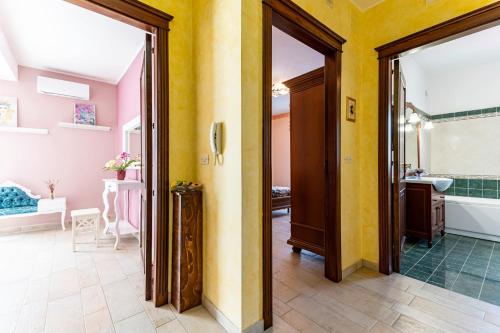 a bathroom with yellow walls and a tub and a sink at GuestHost - Eden Green Oasis in Giardini Naxos
