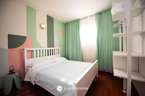 una camera con letto bianco e pareti verdi di Specchio sul Lago a Manerba del Garda