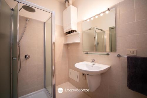 un bagno con lavandino e doccia con specchio di Specchio sul Lago a Manerba del Garda