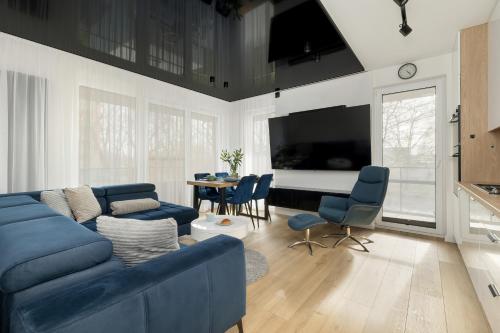 a living room with a blue couch and a table at Stylish Apartment Wyspa Solna by Renters Prestige in Kołobrzeg
