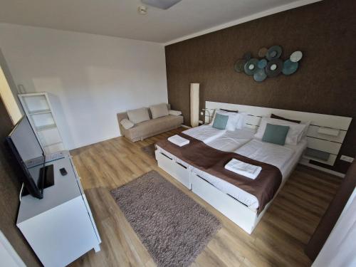 a bedroom with a large bed and a couch at Apartment Sunrise in Zalakaros