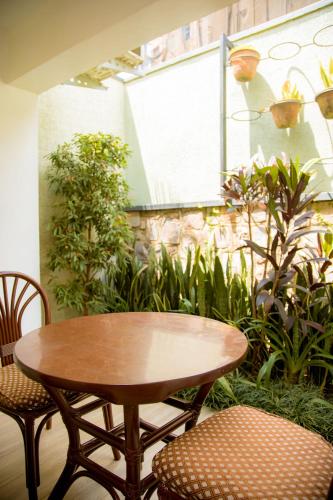 a table and chairs in a room with plants at Saphir Boutique Hotel in Kigali