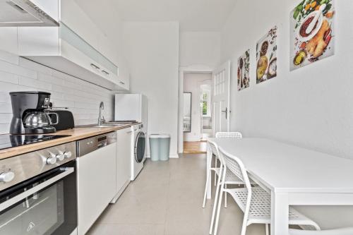 a kitchen with a white table and a white table and chairs at Nice Apartment in Eberswalde in Eberswalde