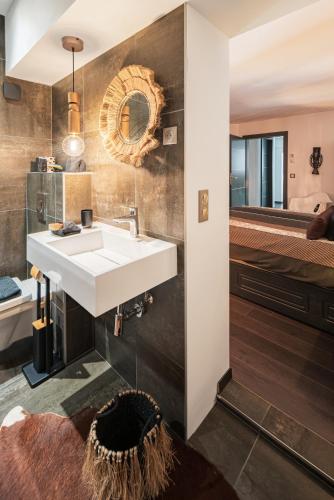 une salle de bain avec un lavabo et un miroir dans l'établissement ALSACE Cosy, à Schoenau