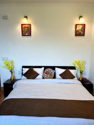 a bedroom with a large white bed with pillows at Dolia Pahadi Myar Maiti in Rānīkhet