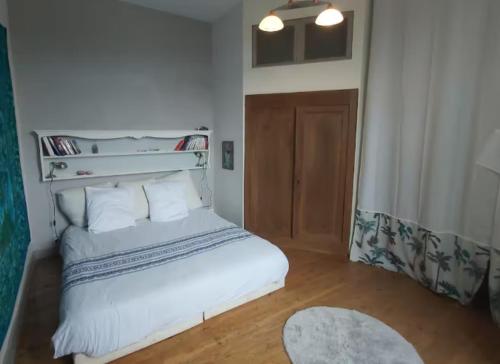 - une chambre avec un lit blanc et du parquet dans l'établissement Coeur des grands crus médoc, à Saint-Estèphe