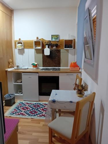 a kitchen with a table and a small table and a table and a kitchen at D,apartman' ulica pušća 51, 51513 Omišalj in Omišalj